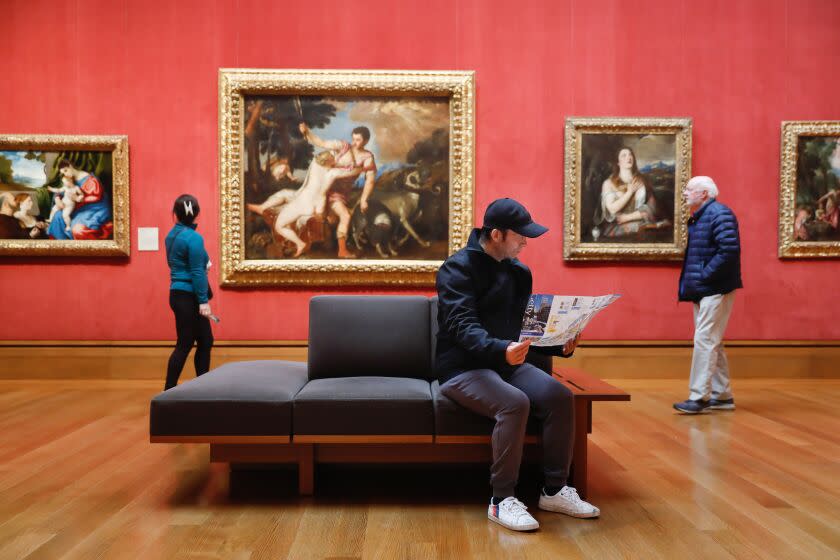 LOS ANGELES-CA-MARCH 21, 2023: Wei Xin Yang, visiting from Toronto, looks over a museum map while having a seat on a bench at The Getty on March 21, 2023. (Christina House / Los Angeles Times)