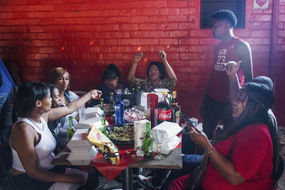 <p>Some teenagers during a braai, at Mzoliâs Butchery, eating and drinking alcohol. Alcoholism combined with the quantity and low quality of food has increased the rate of obesity among young people. An example of the evolution of globesity is South Africa, with an obesity rate nearly double the global average and on its way to becoming one of the world’s fattest nations. (Photograph by Silvia Landi) </p>