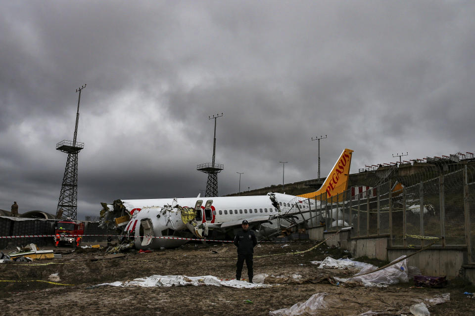 Un policía vigila la zona donde el día previo un avión se salió de la pista del aeropuerto Sabiha Gokcen, en Estambul, el jueves 6 de febrero de 2020. (AP Foto/Emrah Gurel)