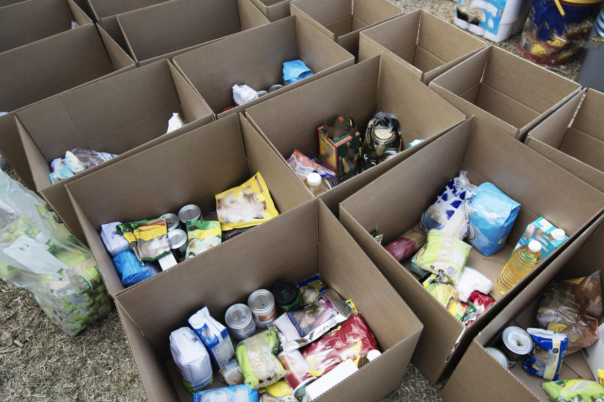 Cardboard boxes being filled with food donations for Coronavirus disaster relief.