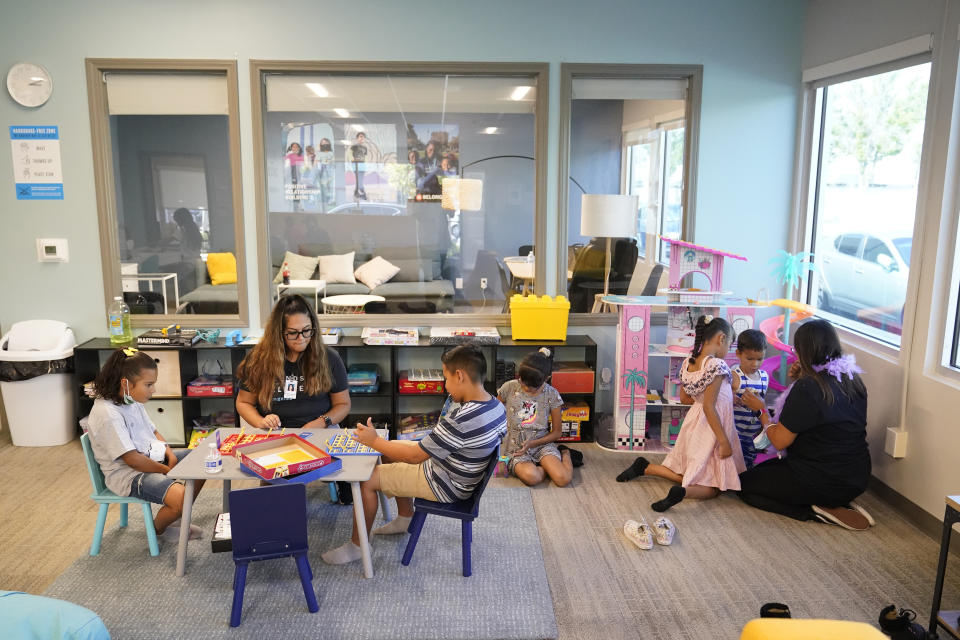 Mentors play games with kids at a Friends of the Children office Wednesday, Aug. 24, 2022, in Lancaster, Calif. Billionaire philanthropist MacKenzie Scott donated $44 million to the Oregon-based mentoring organization, Friends of the Children, which supports children at risk of entering the welfare system by pairing them with a longtime mentor. (AP Photo/Marcio Jose Sanchez)