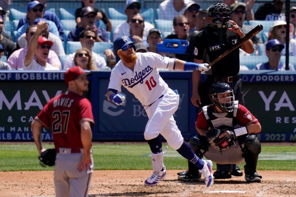 Los Angeles Dodgers' Justin Turner, second from left, runs to first as he hits a three-run home run as Arizona Diamondbacks starting pitcher Zach Davies, left, watches along with catcher Daulton Varsho, right, and home plate umpire Roberto Ortiz during the fourth inning of a baseball game Wednesday, May 18, 2022, in Los Angeles. (AP Photo/Mark J. Terrill)