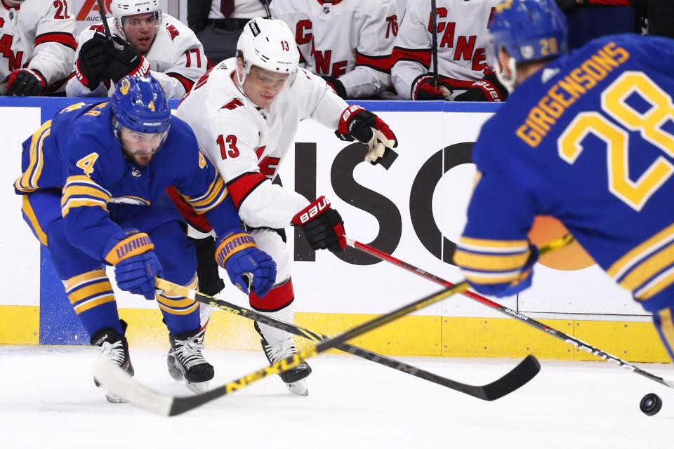 Carolina Hurricanes center Max Domi (13) checks Buffalo Sabres defenseman Will Butcher (4) during the first period of an NHL hockey game Tuesday, April 5, 2022, in Buffalo, N.Y. (AP Photo/Jeffrey T. Barnes)