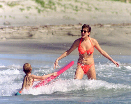 Princess of Wales plays in the surf with Prince William during a beach outing on the Caribbean island of St Kitts January 4, 1993. REUTERS/Mark Cardwell