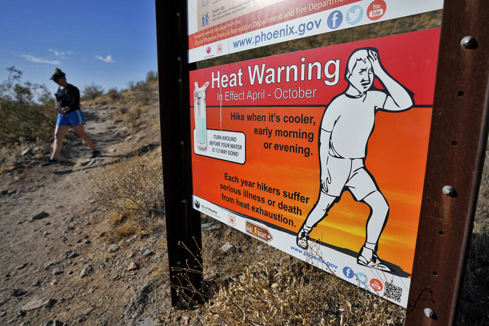A hiker finishes her hike early to beat high temperatures, Monday, July 10, 2023 in Phoenix. National Weather Service says Phoenix has had 10 consecutive days of 110 degrees or above. (AP Photo/Matt York)