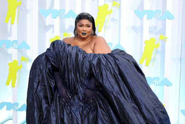 Lizzo looks striking in dark lipstick as she models a black top