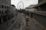 Big Ben's clock tower and the London Eye ferris wheel stand in the distance as the area around Royal Festival Hall is very quiet in London, Wednesday, April 8, 2020. The new coronavirus causes mild or moderate symptoms for most people, but for some, especially older adults and people with existing health problems, it can cause more severe illness or death. (AP Photo/Matt Dunham)