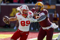 Nebraska wide receiver Oliver Martin (89) eludes the grasp of Minnesota defensive lineman Esezi Otomewo (9) in the fourth quarter of an NCAA college football game, Saturday, Oct. 16, 2021, in Minneapolis. Minnesota won 30-23. (AP Photo/Bruce Kluckhohn)