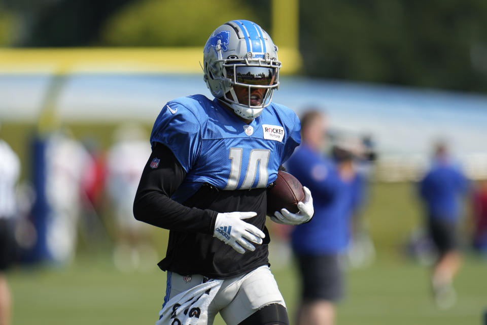 Detroit Lions wide receiver Amon-Ra St. Brown runs with the ball during an NFL football practice in Allen Park, Mich., Wednesday, Aug. 9, 2023. (AP Photo/Paul Sancya)