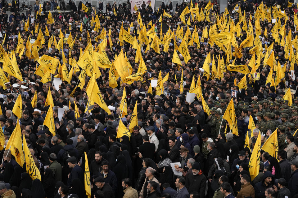 Iranian mourners attend the funeral ceremony of Seyed Razi Mousavi, a high ranking Iranian general of the paramilitary Revolutionary Guard, who was killed in an alleged Israeli airstrike in Syria on Monday, as they carry flags which read in Farsi " I'm your opponent," showing their readiness to fight Israel, in Tehran, Iran, Thursday, Dec. 28, 2023. (AP Photo/Vahid Salemi)