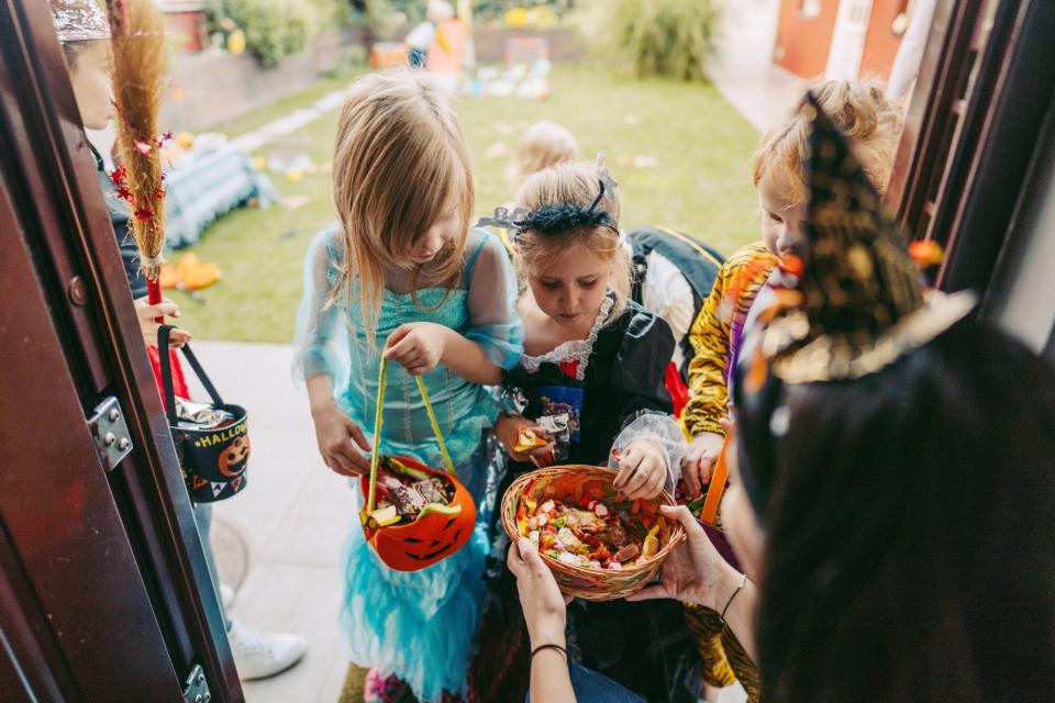 passing out halloween candy to trick or treaters