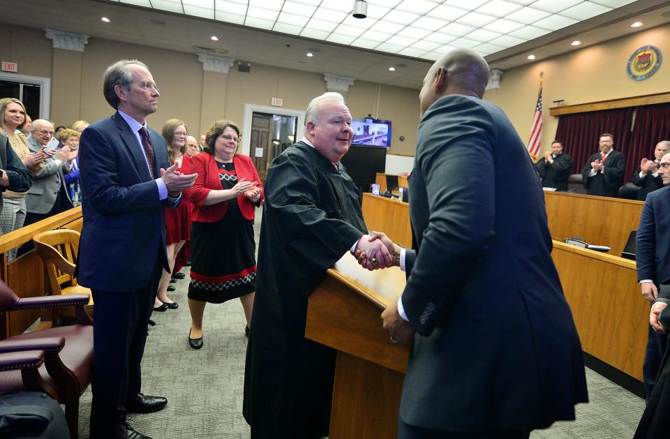 Kirk C. Downey shakes hands with Maryland Gov. Wes Moore after being sworn in as associate judge of Washington County Circuit Court on Friday in the main courtroom of the old courthouse in Hagerstown. Among those looking on are Downey's wife, Eileen, and Hagerstown attorney Bruce Poole, who chaired the Judicial Nominating Commission.