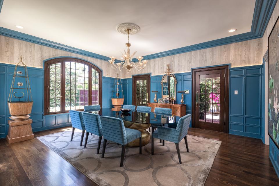 The formal dining room is decorated in a rich blue tone.