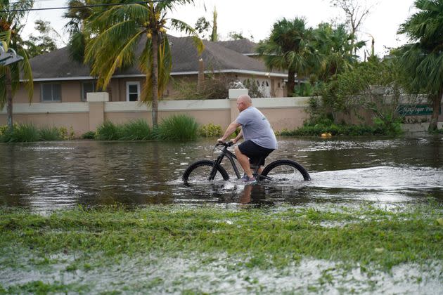 A man tries to ride bike in the flooding in Fort Myers on Sept. 29. (Photo: Anadolu Agency via Getty Images)