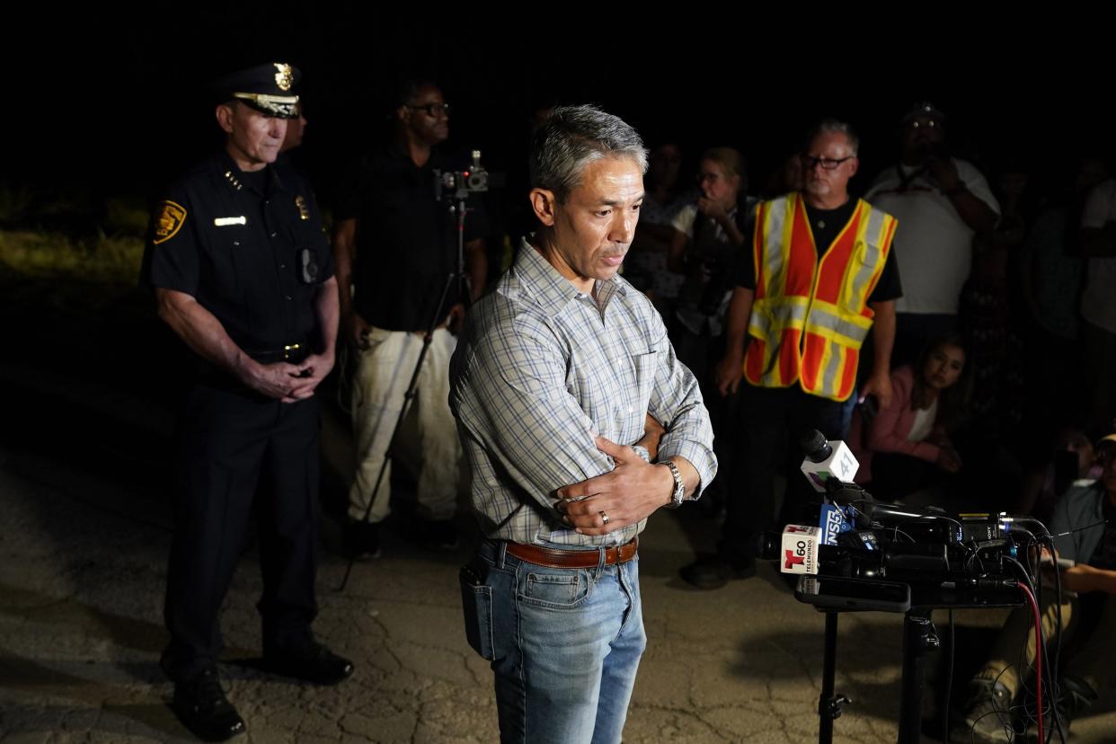 San Antonio Mayor Ron Nirenberg, center, with San Antonio Police Chief William McManus, left, brief media and others at the scene where they said dozens of people have been found dead and multiple others were taken to hospitals with heat-related illnesses after a semitrailer containing suspected migrants was found on Monday, June 27, 2022, in San Antonio.