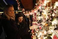 People shop at a Christmas market on the South Bank on the last Sunday before Christmas, in London December 22, 2013. REUTERS/Luke MacGregor