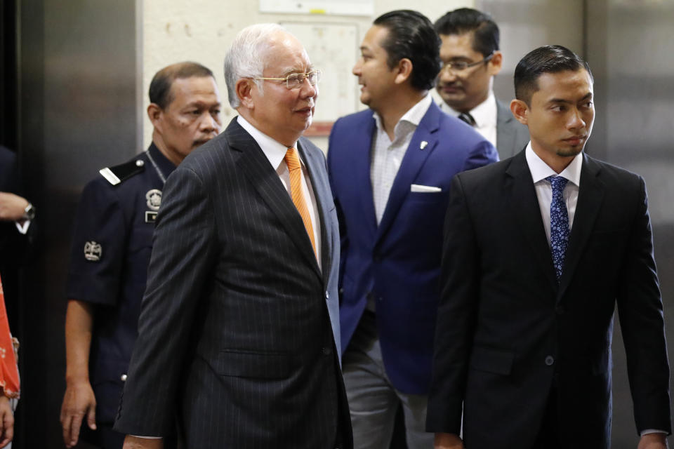 Former Malaysian Prime Minister Najib Razak, left in foreground, arrives at Kuala Lumpur High Court in Kuala Lumpur, Monday, Nov. 11, 2019. An important court ruling Monday in the first corruption trial of Najib will be a test of the legal system and of the credibility of the prime minister who brought about his shocking ouster from office last year. (AP Photo/Vincent Thian)