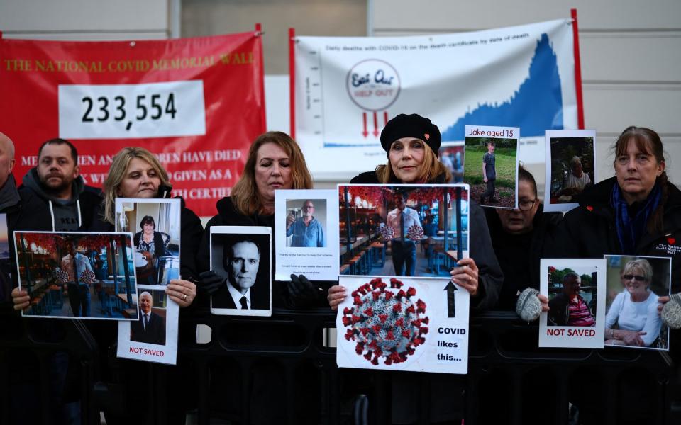 Relatives of those who died during the pandemic hold placards as they gathering outside the UK Covid Inquiry