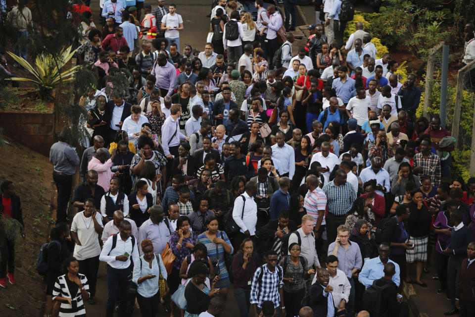 Rescued civilians gather at a safe place after a blast in Nairobi, Kenya, Tuesday, Jan. 15, 2019. Extremists launched a deadly attack on a luxury hotel in Kenya's capital Tuesday, sending people fleeing in panic as explosions and heavy gunfire reverberated through the complex. A police officer said he saw bodies, "but there was no time to count the dead." (AP Photo/Brian Inganga)