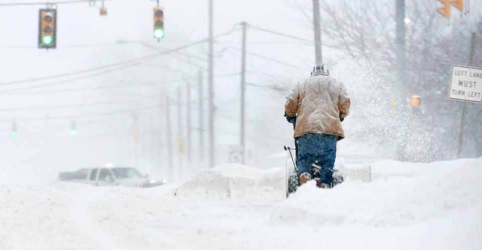 A man clears snow on Jan. 17, 2022, near West 12th St. and Powell Avenue in Millcreek Township. A heavy overnight snowfall greeted motorists at daybreak although schools and some businesses were closed due to the Martin Luther King Jr. holiday, reducing traffic.