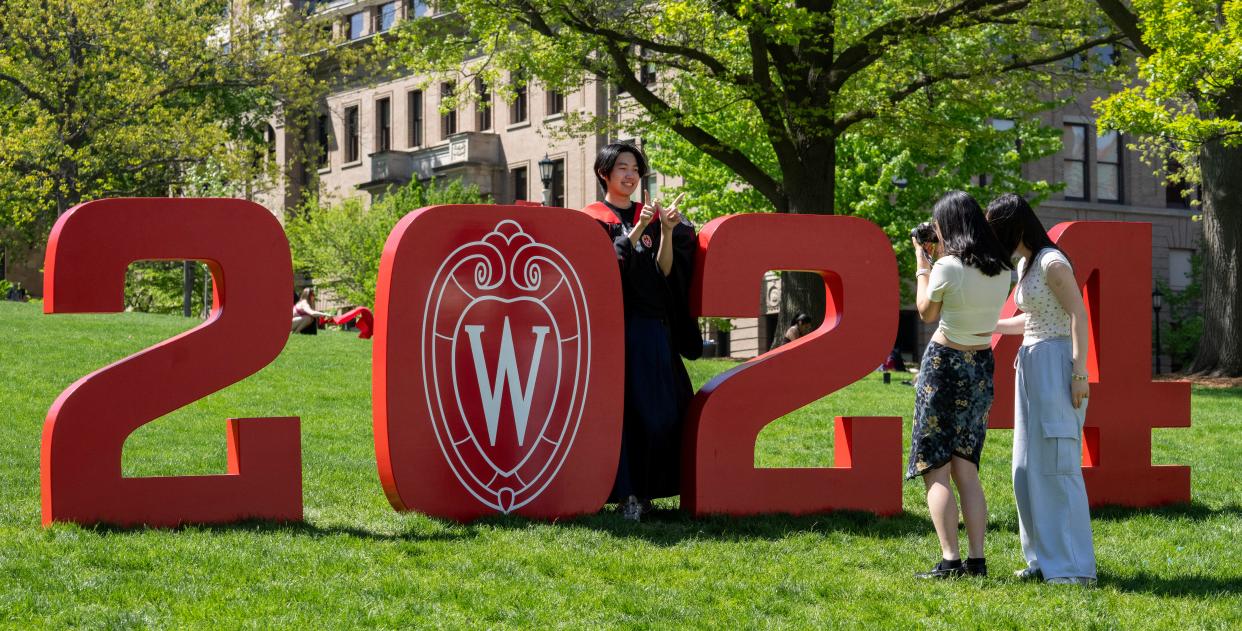 A  man poses for graduation photos on Bascom Hill at the University of Wisconsin-Madison on Monday. UW-Madison is holding its spring commencement ceremonies at Camp Randall Stadium and the Kohl Center this weekend.