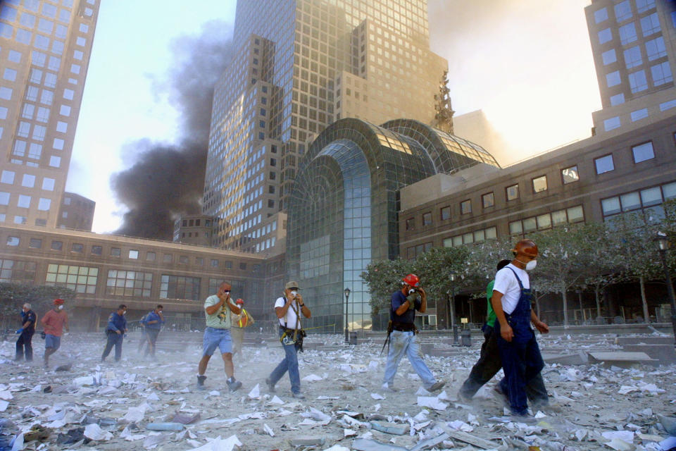 <p>People evacuate the area surrounding the World Trade Center after it was hit by two planes on Sept. 11, 2001. (Photo: Mario Tama/Getty Images) </p>