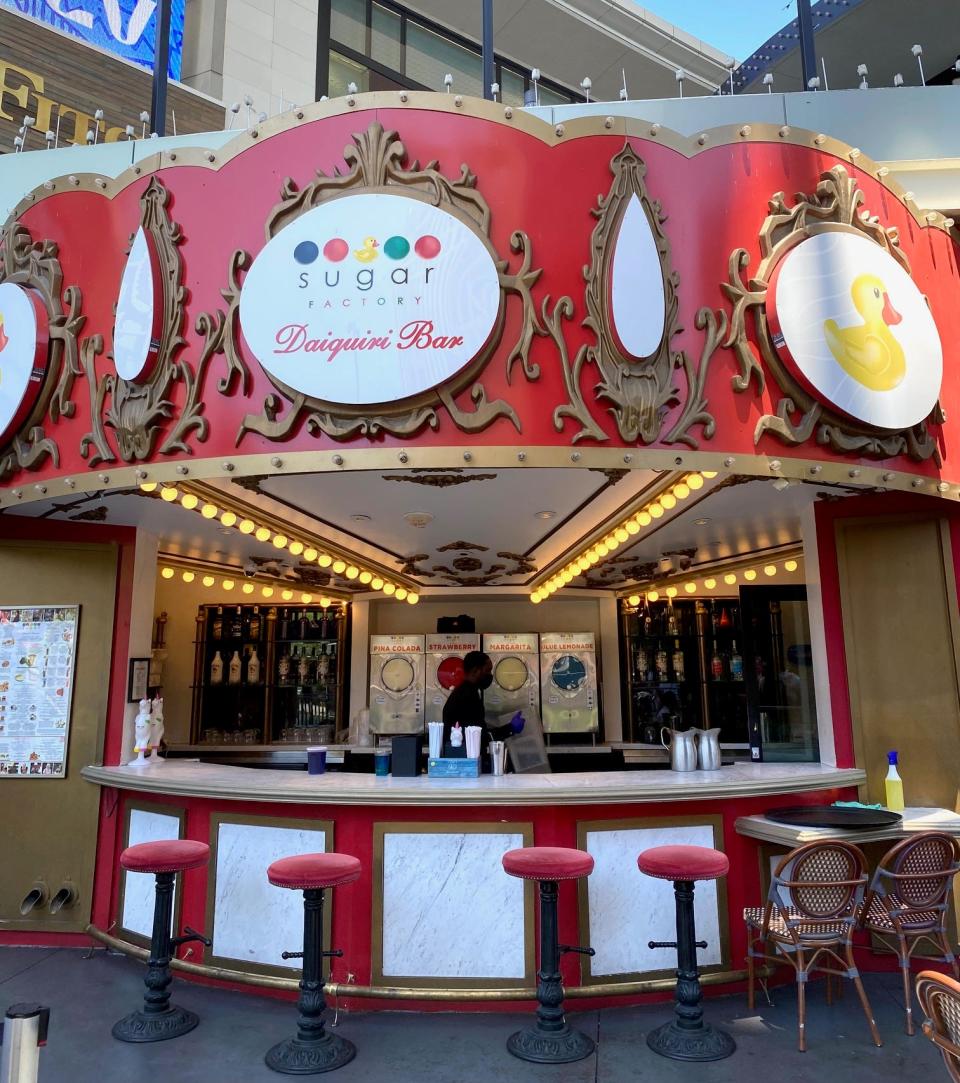 sugar factory in las vegas — red awning with logo on the front in white with daquiri bar below it, four seats at the bar