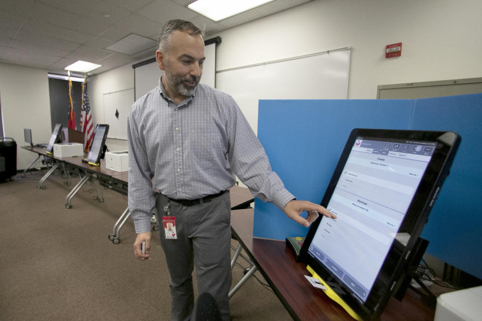 FILE- In this Sept. 16, 2019 file photo, Scott Tucker demonstrates the Dominion Voting system Georgia will use in Atlanta. Republican efforts to question the results of the 2020 election have led to two significant breaches of voting software that have alarmed election security experts who say they have increased the risk to elections in jurisdictions that use the equipment. (AP Photo/John Bazemore, File)