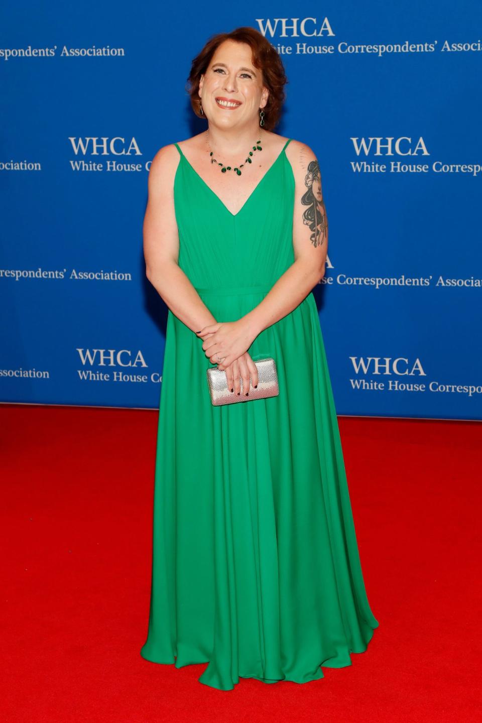 <p>wears a vibrant green Leanne Marshall dress teamed with matching Peggy Li Creations jewelry and a metallic clutch. </p>