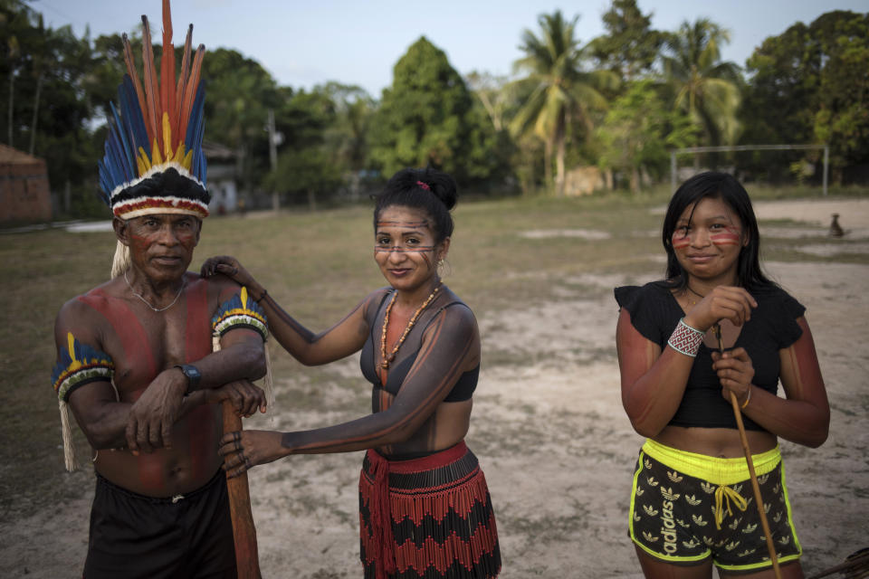 In this Sept. 3, 2019 photo, villagers take take a break during a meeting of Tembé tribes at the Tekohaw indigenous reserve, Para state, Brazil. Deep in the jungle, armed with spears and arrows, they hunt for birds, pigs and other animals. From the trees they take traditional medicines, as well as products they sell, such as acai, an Amazonian berry that’s a vitamin and calorie-packed breakfast staple in Brazil. (AP Photo/Rodrigo Abd)