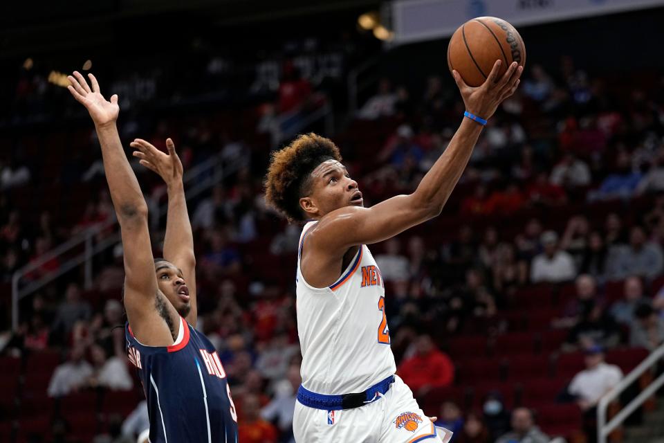 New York Knicks' Miles McBride, right, goes up for a shot as Houston Rockets' Josh Christopher defends during the first half of an NBA basketball game Thursday, Dec. 16, 2021, in Houston. (AP Photo/David J. Phillip)