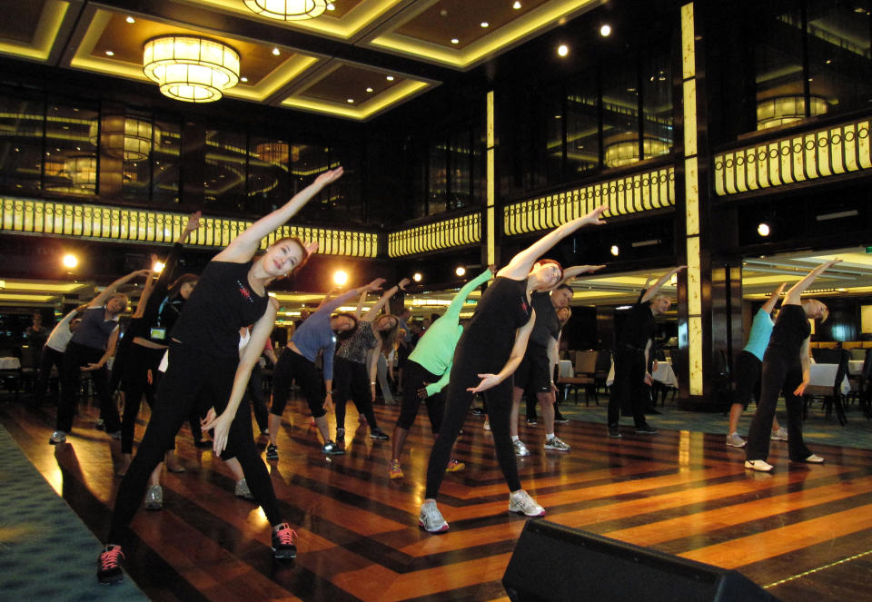 This May 9, 2013 photo shows a fitness class designed by the athletic trainer for the Rockettes, Elaine Winslow, and taught to passengers aboard the Norwegian Breakaway cruise ship. The Rockettes, famed for their kick line at the Radio City Music Spectacular, are the godmothers for the ship. (AP Photo/Beth J. Harpaz)