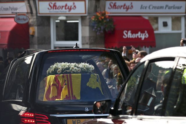 Members of the public line the streets in Ballater, Scotland, as the hearse carrying the coffin of Queen Elizabeth II passes through