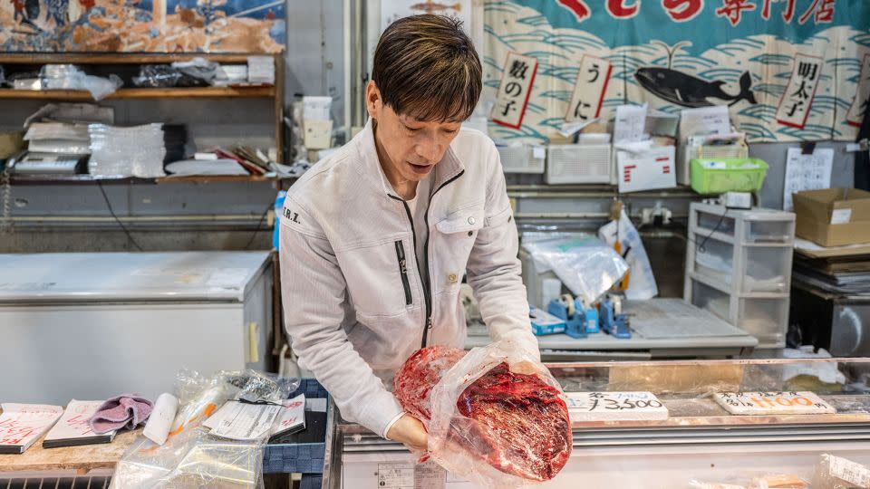The owner of a whale meat shop shows a block of whale meat at the Karato fish market in Shimonoseki city. - Yuichi Yamazaki/AFP/Getty Images