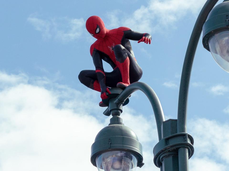 Tom Holland perched on a lamp post as Spider-Man in "Spider-Man: No Way Home."