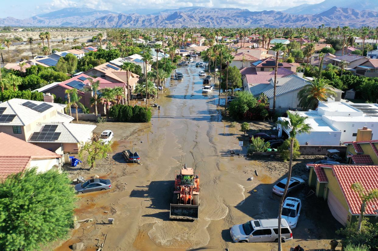 An aerial view of a maintenance vehicle clearing mud near stranded vehicles along a flooded street after Tropical Storm Hilary floodwaters inundated the area on August 21, 2023 in Cathedral City, California. Much of Southern California and parts of Arizona and Nevada are cleaning up after being impacted by the tropical storm that brought several inches of rain that flooded roadways and winds that toppled trees and power lines across the region (Getty Images)