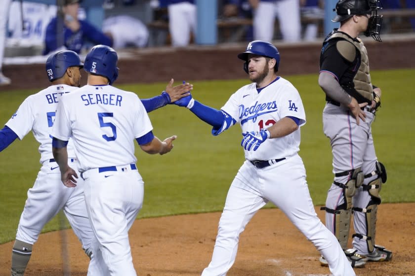 Los Angeles Dodgers' Max Muncy, second from right, is congratulated by Mookie Betts, left, and Corey Seager.