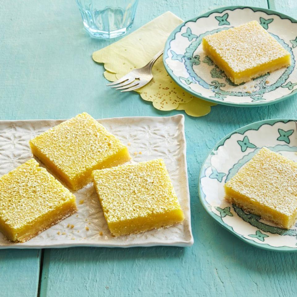 lemon bars on white plate with teal background