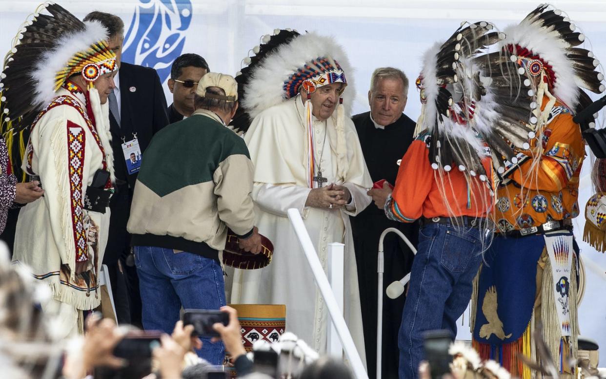 Pope Francis receives a traditional headdress after apologizing near the site of the former Ermineskin Residential School, in Maskwacis, Alta. THE CANADIAN PRESS/Jason Franson