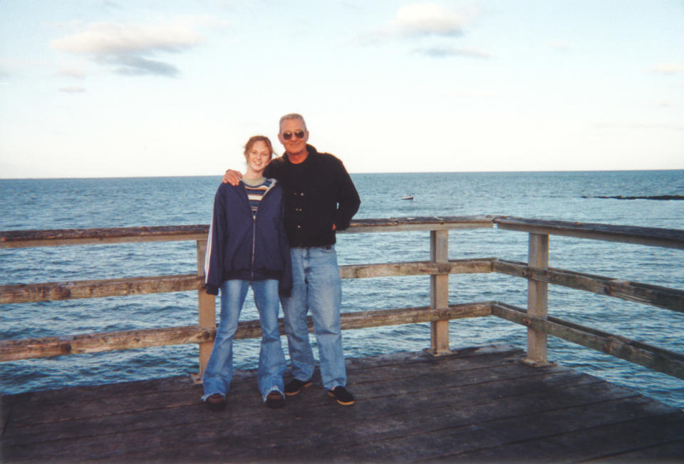 daughter with her dad posing by the water