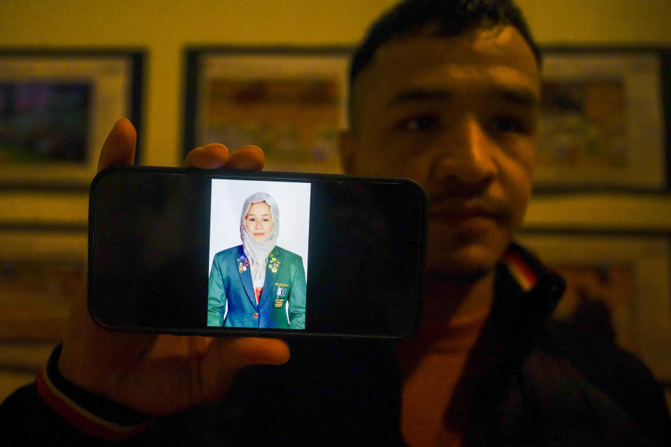 Ali Raza, 24, from Pakistan, shows his phone in Crotone, southern Italy, with a picture of his 29-year-old sister Shahida Raza, 29, captain of the Pakistani hockey national team, who was killed when a migrant boat capsized in the early morning of Sunday, Feb. 26, 2023, at a short distance from the shore in Steccato di Cutro, in the Italian southern tip, killing at least 94 people. Survivors and family members of the victims are converging in the area for a commemoration on Monday, Feb. 26, 2024, on the first anniversary of the disaster. (AP Photo/Valeria Ferraro)