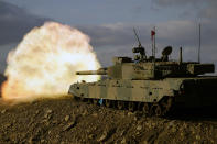 Japanese Ground-Self Defense Force (JGDDF) Type 90 tank fires its gun at a target during a live-fire annual exercise at the Minami Eniwa Camp Monday, Dec. 6, 2021, in Eniwa, on the northern Japan island of Hokkaido. Dozens of tanks are rolling over the next two weeks on Hokkaido, a main military stronghold for a country with perhaps the world's most little known yet powerful army. (AP Photo/Eugene Hoshiko)