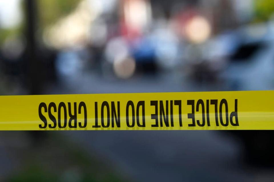 Police tape is stretched across a street. (Photo by Mark Makela/Getty Images)