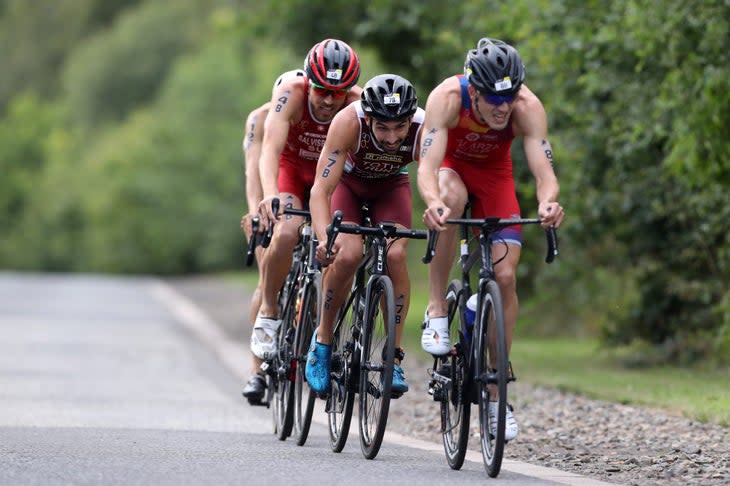Four male athletes ride in a pack during a triathlon mixed relay.