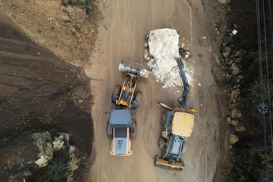 Caltrans workers chip away at a huge boulder that fell on Malibu Canyon Road on Jan. 10, 2023, in Malibu, California.