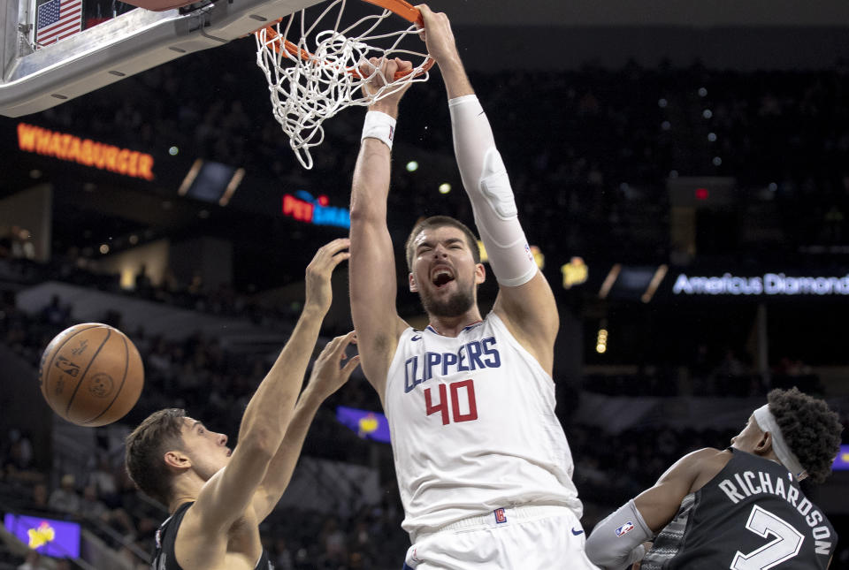 Los Angeles Clippers center Ivica Zubac (40) dunks over San Antonio Spurs forward Zach Collins, left, and guard Josh Richardson (7) during the second half of an NBA basketball game, Friday, Nov. 4, 2022, in San Antonio. (AP Photo/Nick Wagner)