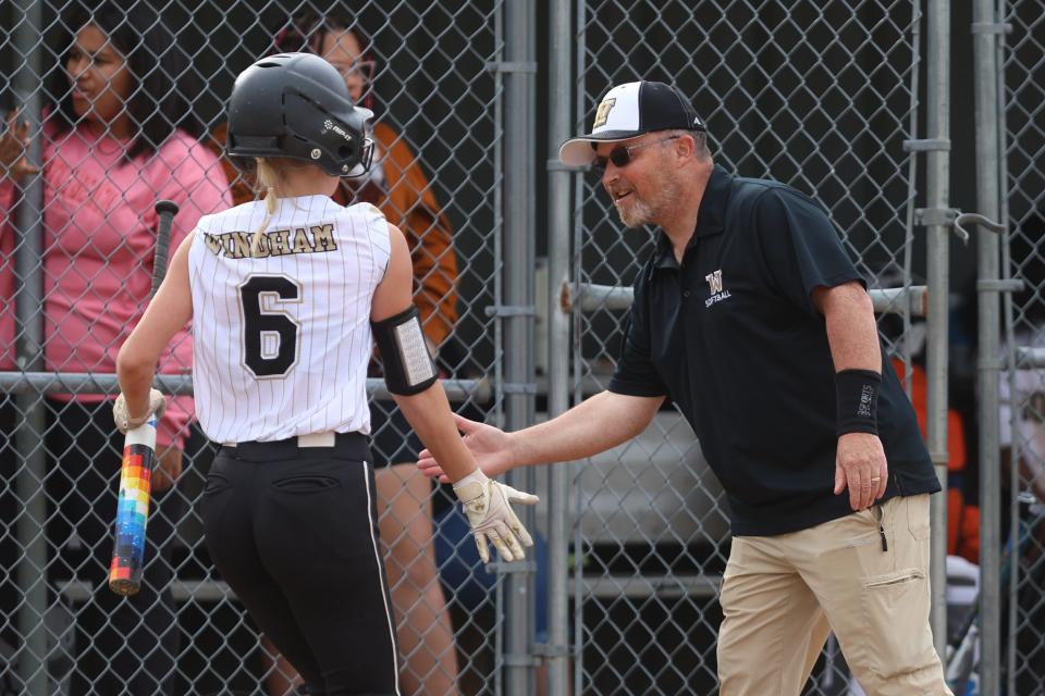Windham’s Makenzi Bryson gets a high-five from head coach Thomas VanKirk after hitting a home run during Monday night’s softball game against Kidron Central Christian in Windham.