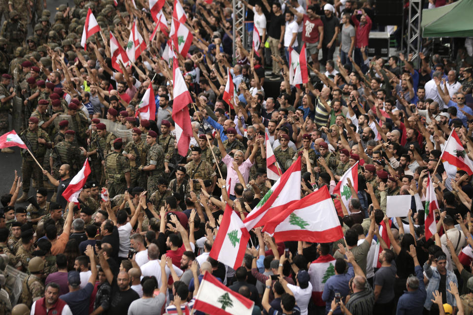 Anti-government protesters shout slogans against the Lebanese government during a protest in the town of Jal el-Dib north of Beirut, Lebanon, Wednesday, Oct. 23, 2019. Lebanese troops have moved in to open several major roads in Beirut and other cities, scuffling in some places with anti-government protesters who had blocked the streets for the past week. (AP Photo/Hassan Ammar)