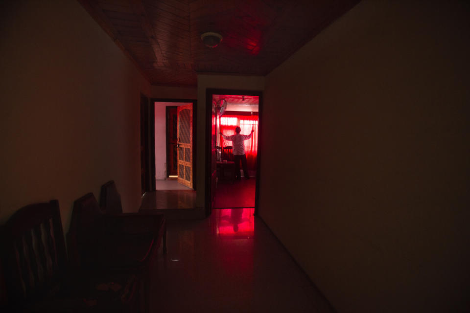 Kashmiri waiter Ghulam Nabi adjusts the curtains inside an unoccupied room at Hotel New York during a lockdown to stop the spread of the coronavirus in Srinagar, Indian controlled Kashmir, July 15, 2020. Indian-controlled Kashmir's economy is yet to recover from a colossal loss a year after New Delhi scrapped the disputed region's autonomous status and divided it into two federally governed territories. (AP Photo/Mukhtar Khan)