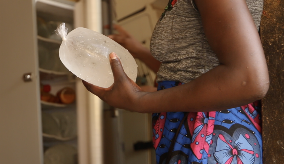 A woman holding an ice bag in Bamako, Mali.